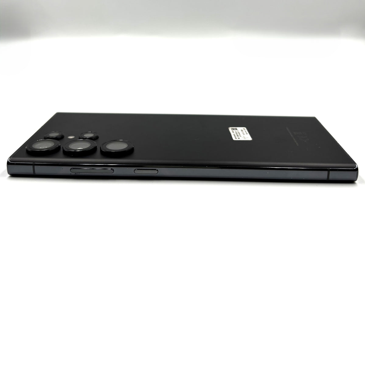 A black Samsung Galaxy S23 Ultra shown from the back, positioned horizontally against a clean white background.