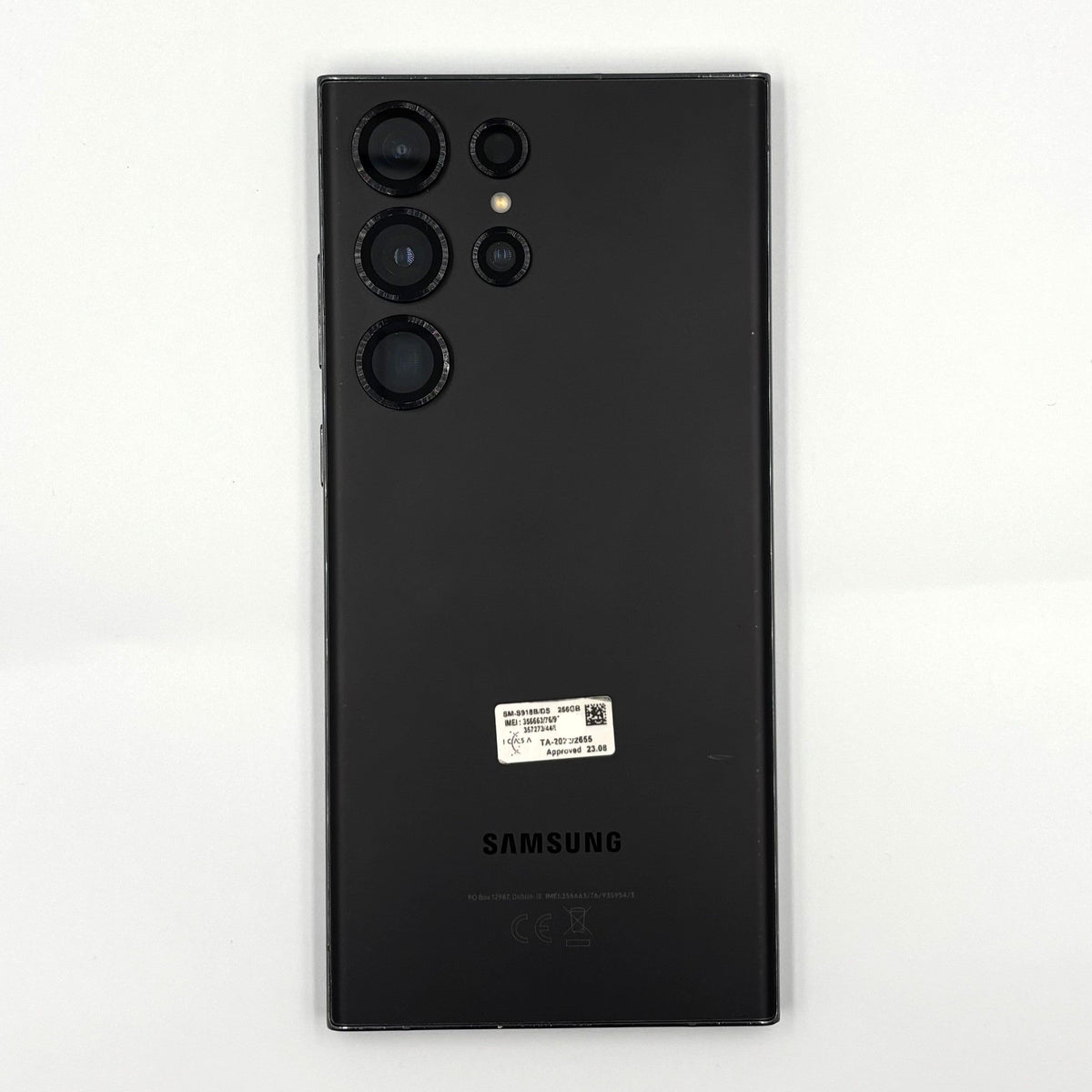 A black Samsung Galaxy S23 Ultra smartphone shown from the back, featuring its triple-camera system and a small white product sticker, set against a plain white background.