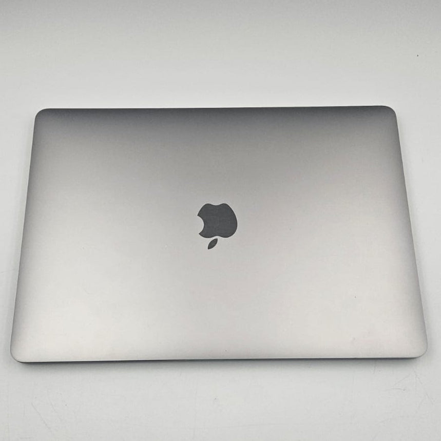 A closed silver Apple MacBook pro , shown from the top lid against a plain light gray background.