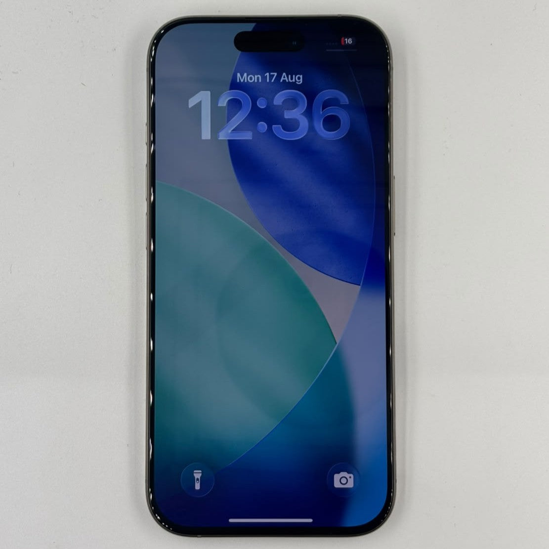 IPhone 16 Pro front showing display with blue wallpaper on white background